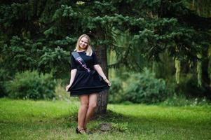 Portrait of gorgeous girl wear on black at hen party, posed at park. photo