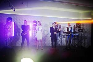 banda de música musical en vivo actuando en un escenario con diferentes luces. foto