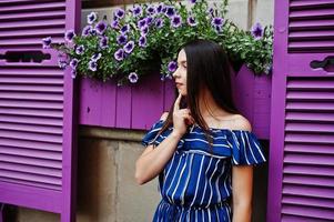 Gorgeous brunette girl portrait background violet windows. photo