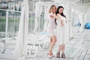 Two girls posed at hen party on the pier of beach. photo