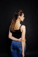 Studio portrait of back hairdress brunette girl  on black background. photo