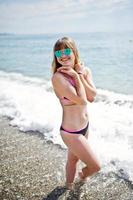 Beautiful model relaxing on a beach dressed in a swimsuit. photo