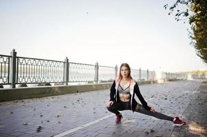Young girl has the training and doing exercise outdoors. Sport, fitness, street workout concept. photo