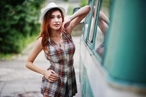 Amazing long legs with hig heels girl wear on hat against old retro minivan. photo