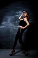 Fashion model red haired girl with originally make up like leopard predator against steel wall. Studio portrait. photo