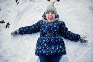 Cute little girl having fun outdoors on winter day. photo