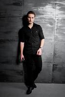 Studio portrait of stylish man wear on black shirt against steel wall. photo