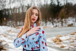 Stylish girl in dress at winter day against frozen lake. photo