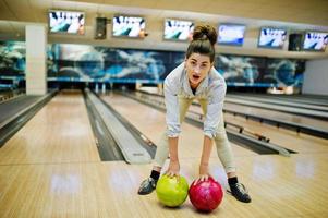 chica con bola de bolos en el callejón jugado en el club de bolos. foto