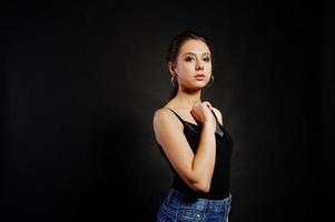 Studio portrait of brunette girl with make up on black background. photo