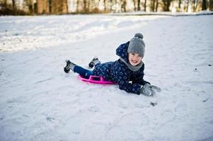 Cute little girl with saucer sleds outdoors on winter day. photo