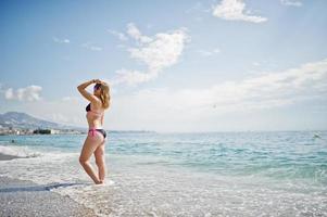 Beautiful model relaxing on a beach dressed in a swimsuit. photo