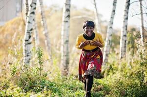 African american girl at yellow and red dress at golden autumn fall park. photo