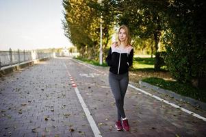 la joven tiene el entrenamiento y hace ejercicio al aire libre. deporte, fitness, concepto de entrenamiento callejero. foto