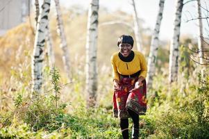 African american girl at yellow and red dress at golden autumn fall park. photo