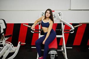 joven hermosa mujer haciendo ejercicios y trabajando duro en el gimnasio y disfrutando de su proceso de entrenamiento. foto