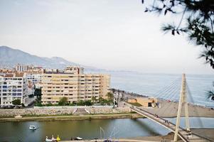 Lovely view at buildings by the sea and tall white bridge. photo