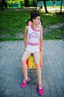 Sport girl wear on white shorts ans shirt doing exercises on simulators outdoor at park. photo