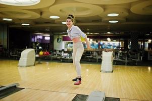 Girl with bowling ball on alley played at bowling club. photo