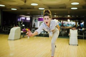 chica con bola de bolos en el callejón jugado en el club de bolos. foto