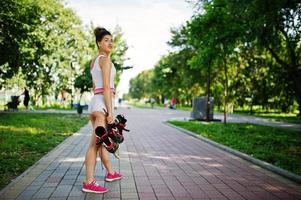 Sport girl wear on white shorts ans shirt with roller skates at park. photo