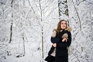 Beautiful brunette girl in winter warm clothing. Model on winter jacket. photo