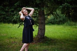 retrato de una hermosa chica vestida de negro en una despedida de soltera, posada en el parque. foto