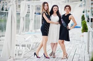 Three girls posed at hen party on the pier of beach. photo