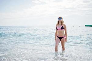 Beautiful model relaxing on a beach dressed in a swimsuit. photo