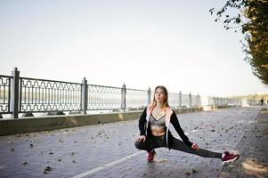 Young girl has the training and doing exercise outdoors. Sport, fitness, street workout concept. photo