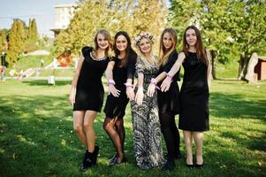 cinco chicas visten de negro divirtiéndose en la despedida de soltera. foto