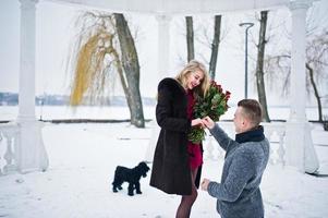 Married proposal with 101 rose at winter day. Loving couple. photo