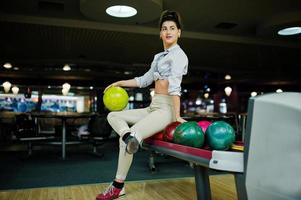 Girl with bowling ball on alley played at bowling club. photo