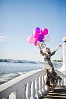 Girl blonde with balloons at hen party against lake. photo