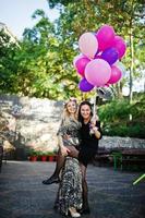 dos chicas visten de negro con globos en la despedida de soltera. foto