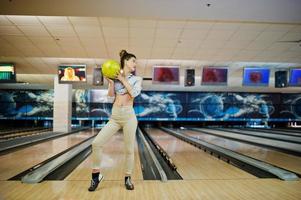 chica con bola de bolos en el callejón jugado en el club de bolos. foto