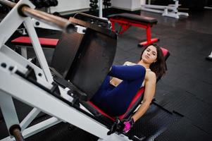 Young beautiful woman doing exercises  and working hard in gym and enjoying her training process. photo