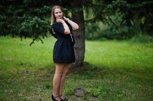 retrato de una hermosa chica vestida de negro en una despedida de soltera, posada en el parque. foto