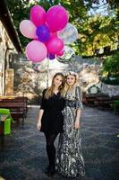 dos chicas visten de negro con globos en la despedida de soltera. foto