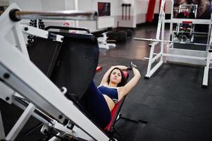 Young beautiful woman doing exercises  and working hard in gym and enjoying her training process. photo