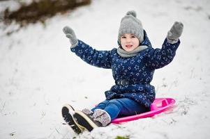 Cute little girl with saucer sleds outdoors on winter day. photo
