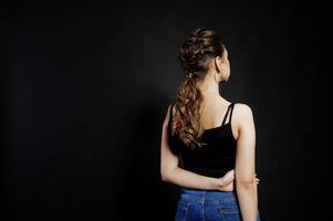 Studio portrait of back hairdress brunette girl  on black background. photo