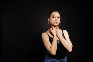 Studio portrait of brunette girl with make up on black background. photo