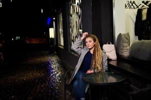 chica con rastas caminando por la calle de noche de la ciudad. foto