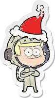happy astronaut distressed sticker cartoon of a wearing santa hat vector