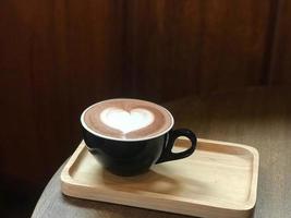 Heart latte art on coffee cup on table photo