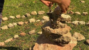 a guy in clear summer weather takes a Chinese rosary from stones video