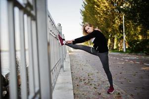 la joven tiene el entrenamiento y hace ejercicio al aire libre. deporte, fitness, concepto de entrenamiento callejero. foto