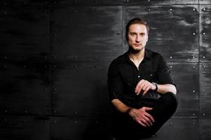 Studio portrait of stylish man wear on black shirt against steel wall. photo