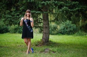 Portrait of gorgeous girl wear on black at hen party, posed at park. photo